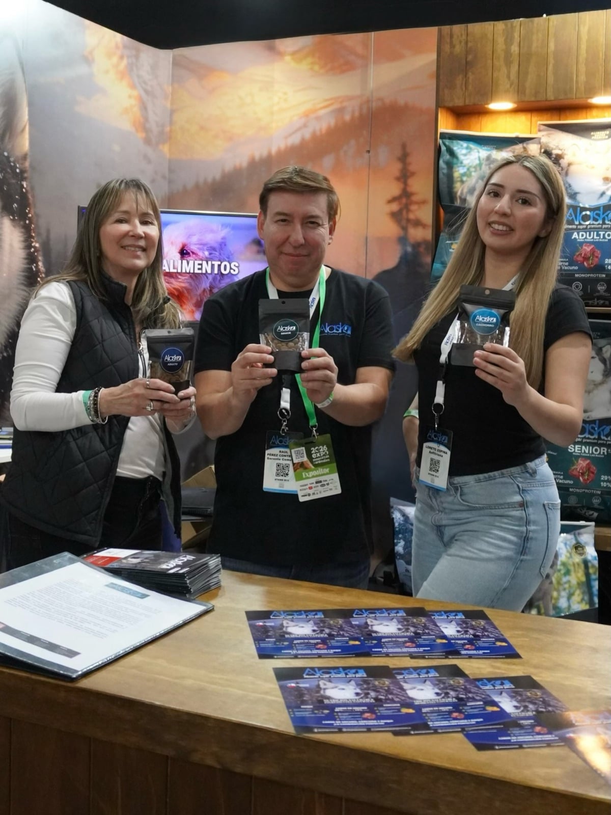 Equipo de Alaska Premium en su stand de feria mostrando el alimento