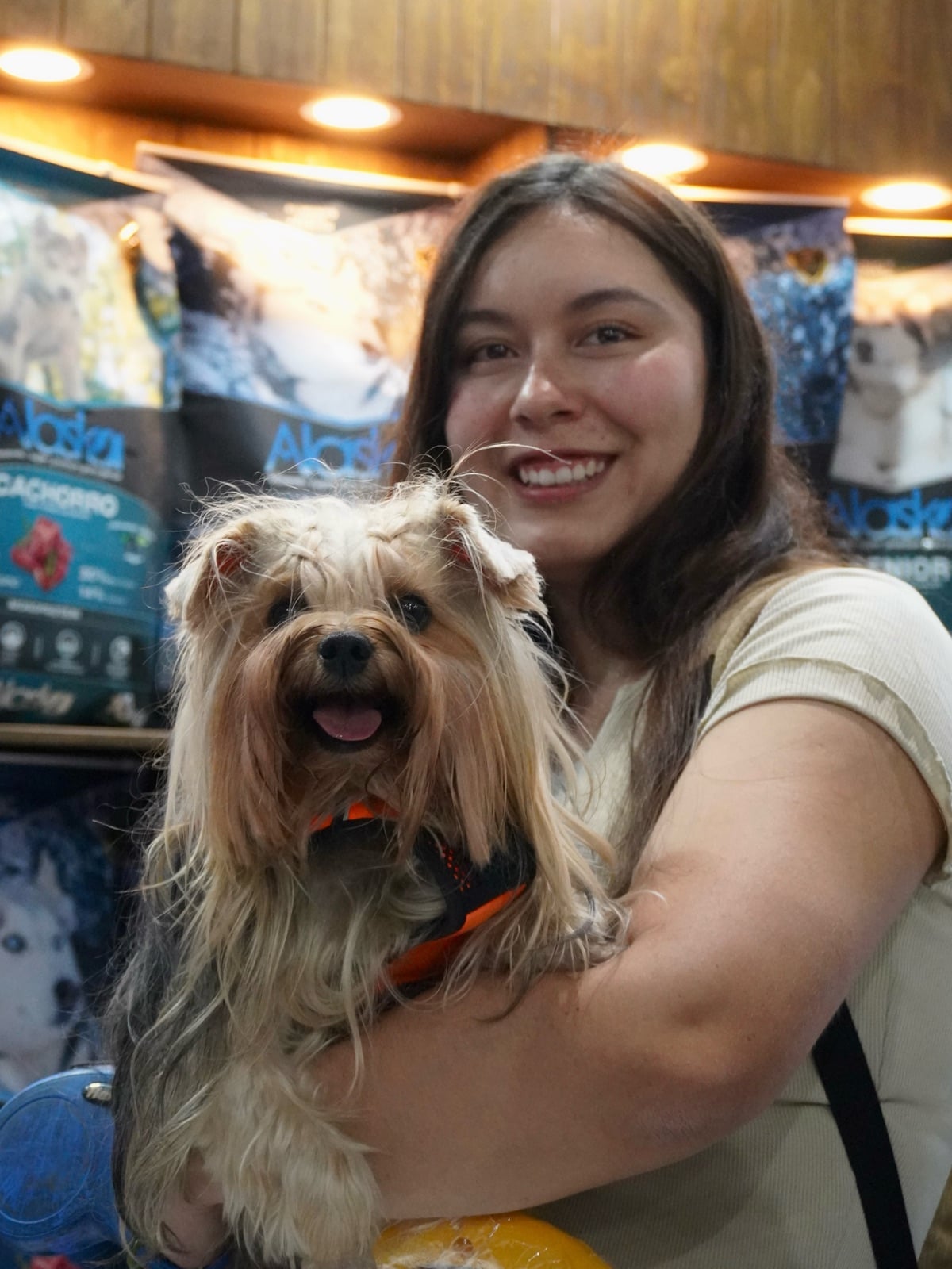 Clienta con su perro yorkshire junto a los sacos de Alaska Cachorro